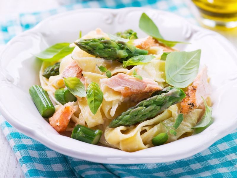 Nudeln mit Lachs und Spargel in einem weißen Teller