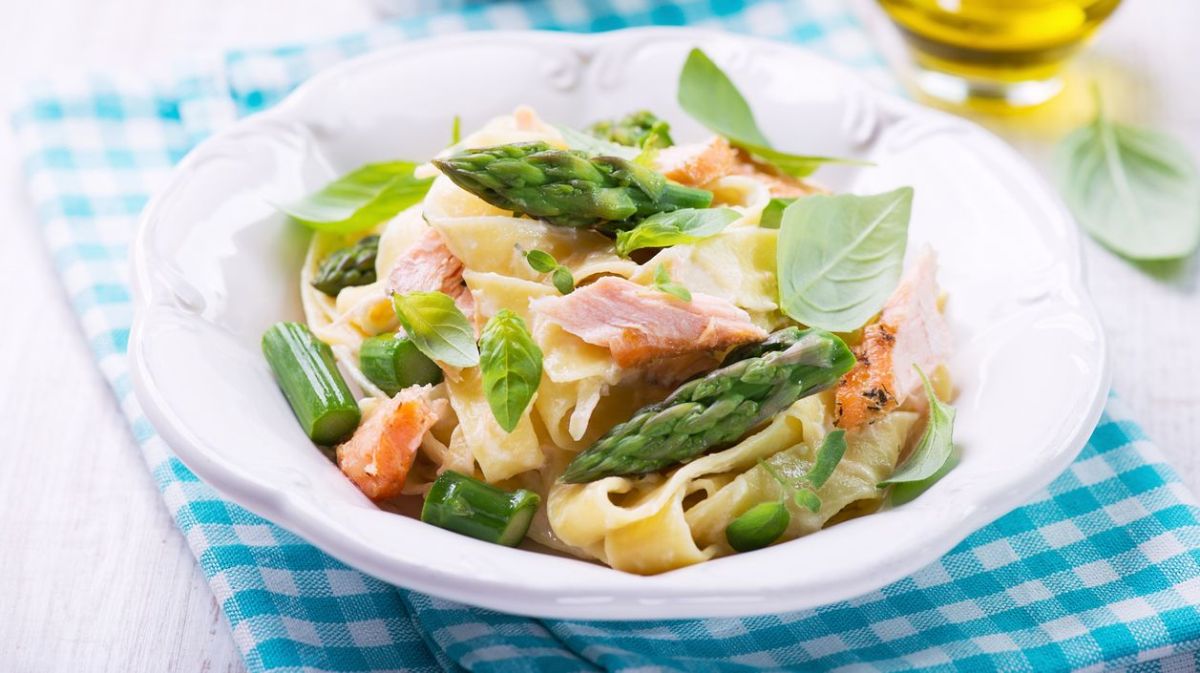 Nudeln mit Lachs und Spargel in einem weißen Teller