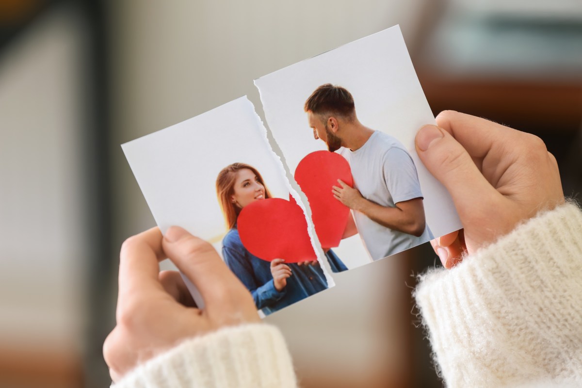 Person hält zerrissenes Pärchenfoto in der Hand