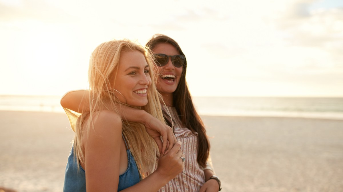 Zwei Freundinnen im Arm am Strand