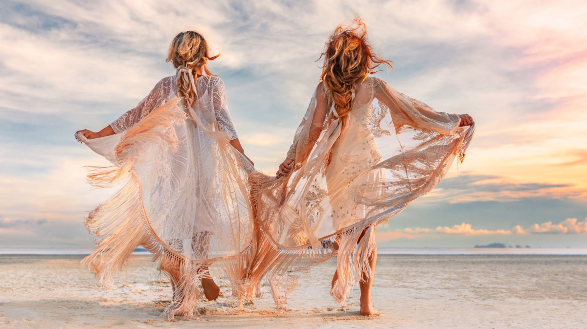 Zwei Frauen mit fließenden Kleidern am Strand