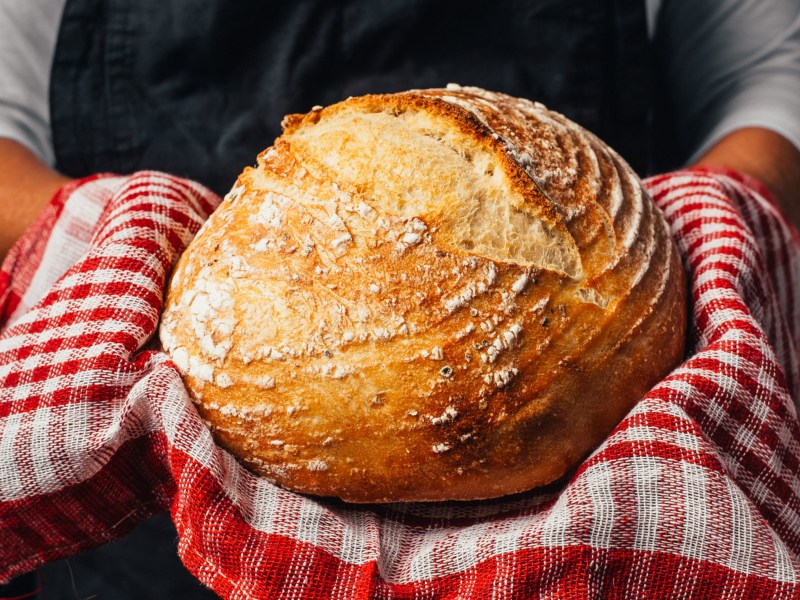 Person hält frisch gebackenen Brot.