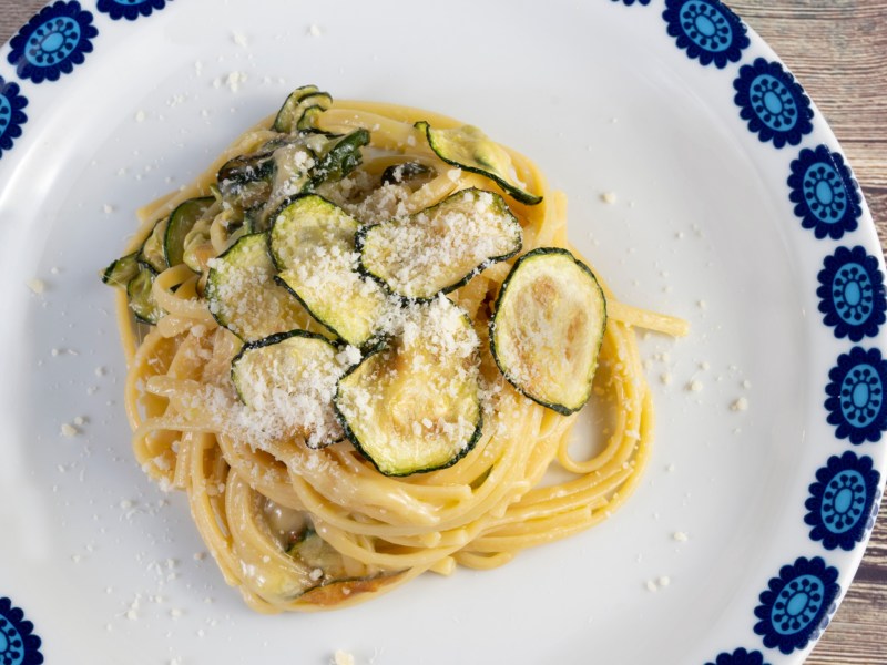 Spaghetti mit Zucchini auf einem hellen Teller.