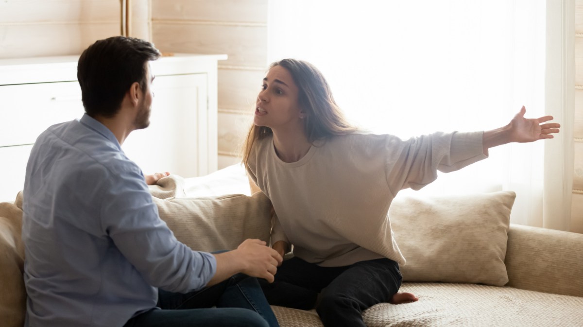 Paar, das sich auf Couch anschreit und streitet