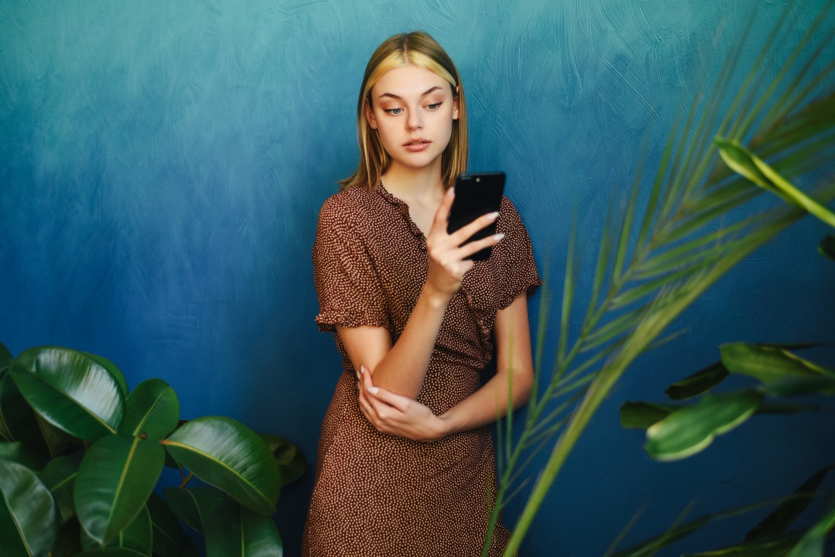 Frau schaut ernst auf ihr Smartphone