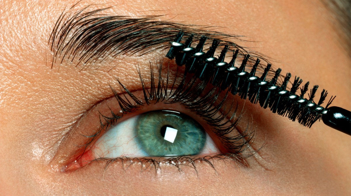 Nahaufnahme eines Auges mit Wimpern und einer Wimpernbürste