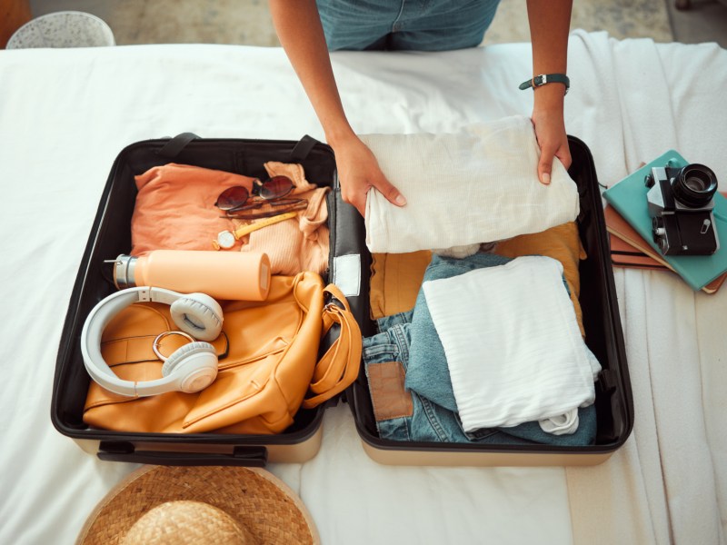 Eine Frau packt ihren Koffer für den Urlaub