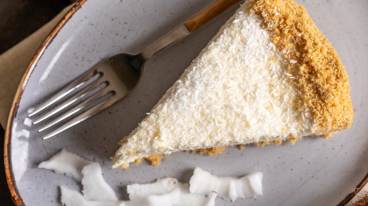 Käsekuchen mit Kokosraspeln auf einem Teller.