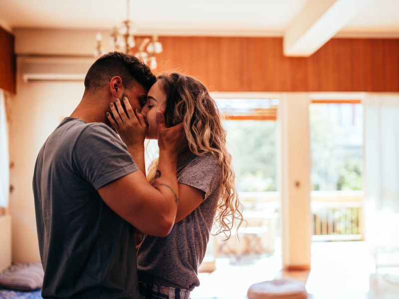 Paar küsst sich verliebt in Wohnzimmer