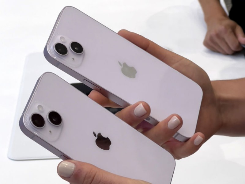 Frau hält zwei neue iPhone 14 in den Händen.