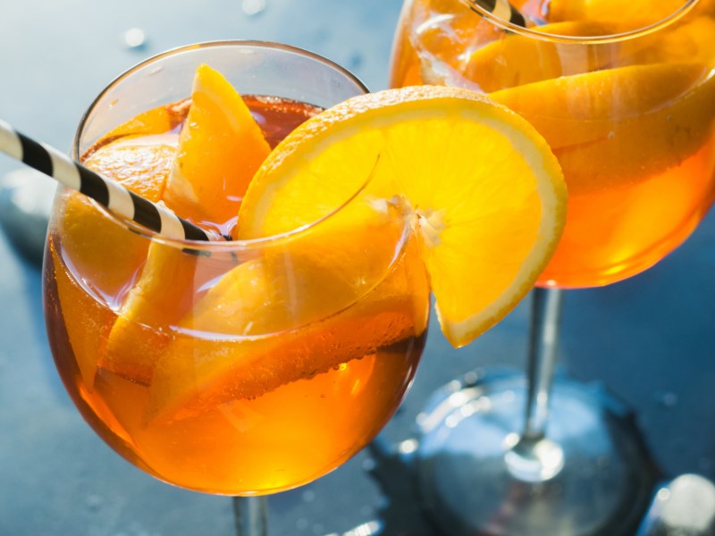 Cocktail mit Orangen und Strohhalm.