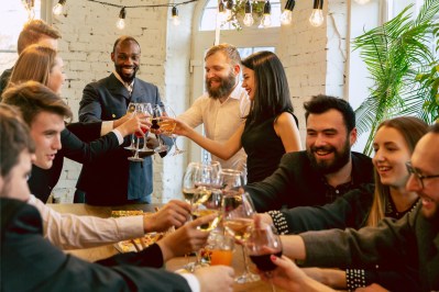 Kolleg*innen sitzen bei einer Firmenfeier gemeinsam am Tisch.