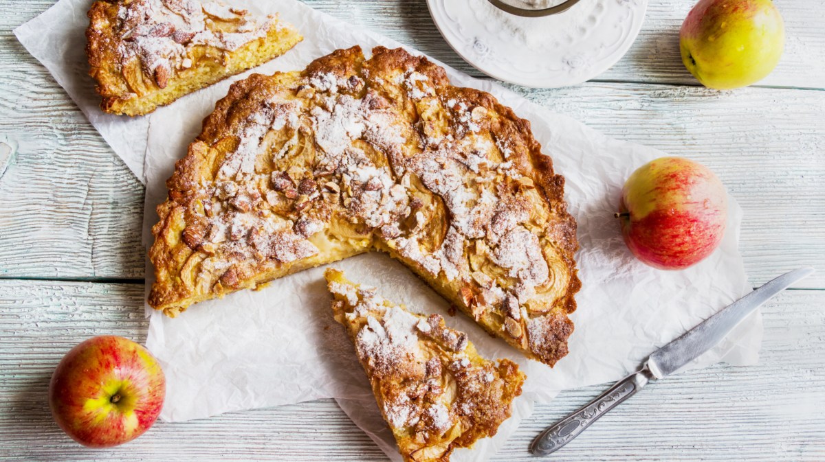 Apfelkuchen mit Mandeln auf weißem Untergrund.