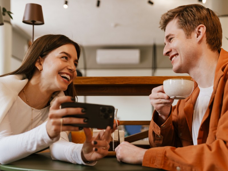 Mann und Frau im Café, die gemeinsam lachen