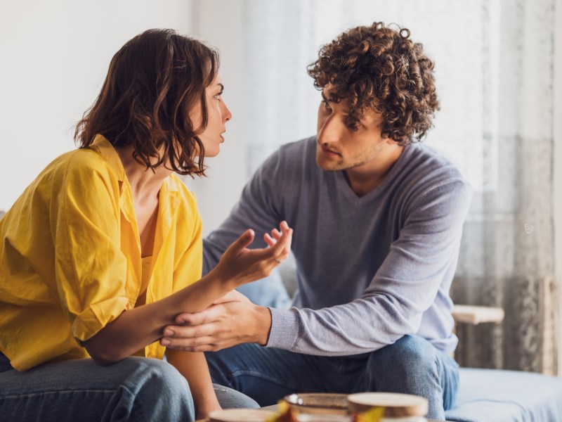 Frau und Mann auf einem Sofa, die miteinander diskutieren