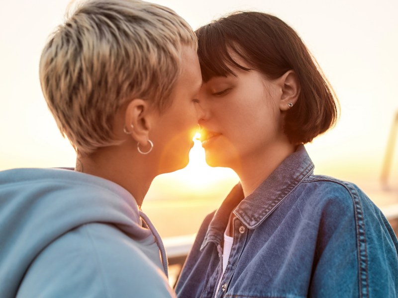 Zwei Frauen sind kurz davor sich zu küssen bei Sonnenaufgang.