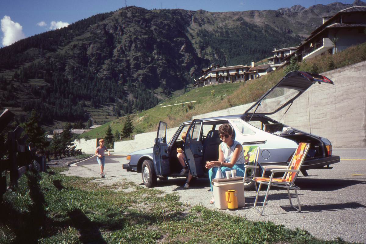 Foto von 1982, geschossen mit einer Analogkamera. Es zeigt eine Familie, die mit dem Auto auf dem Weg in den Sommerurlaub ist, beim Picknick irgendwo in den Schweizer Alpen.
