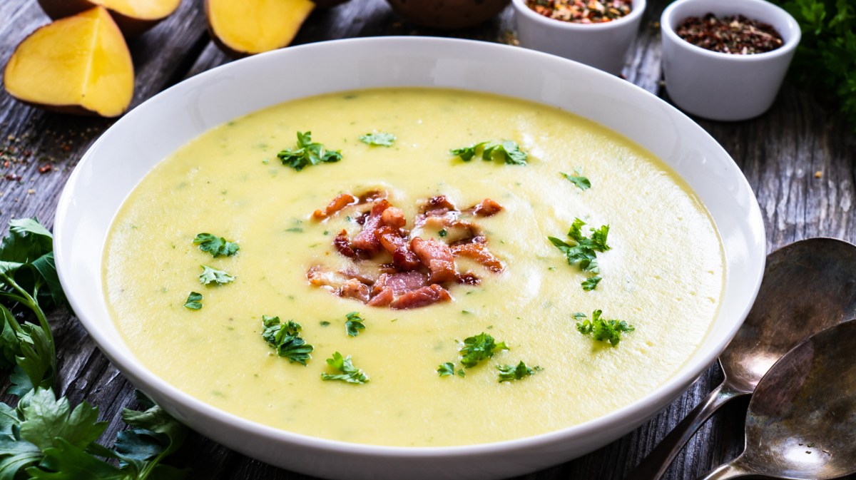 Kartoffelsuppe in weißer Schale mit Speck und Petersilie.