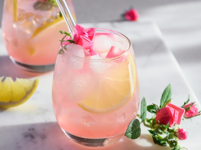 Hugo Rosé, Rosa farbener Cocktail mit Limettenscheiben.