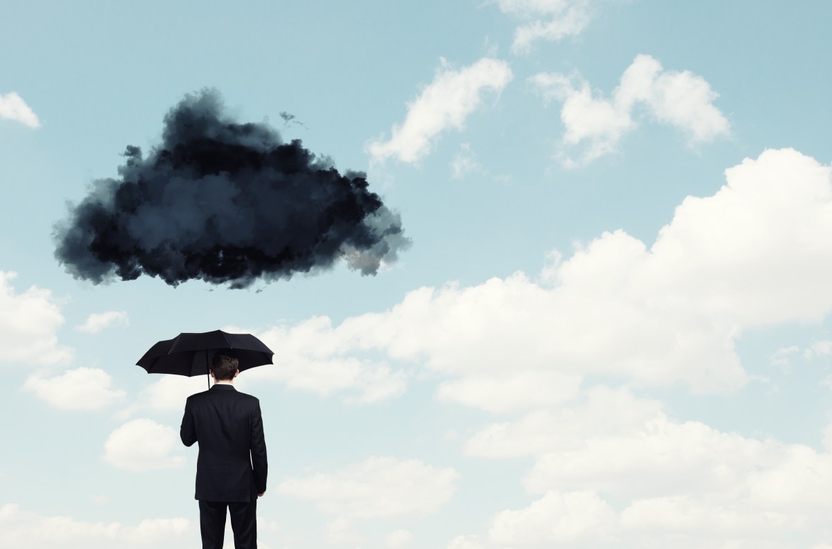 Mensch mit Regenschirm darüber dunkle Wolke