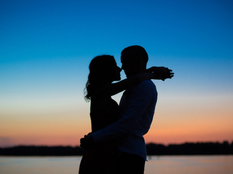 Die Silhouette eines Pärchens beim Sonnenuntergang.