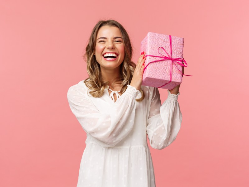 Frau hält ein Weihnachtsgeschenk in der Hand