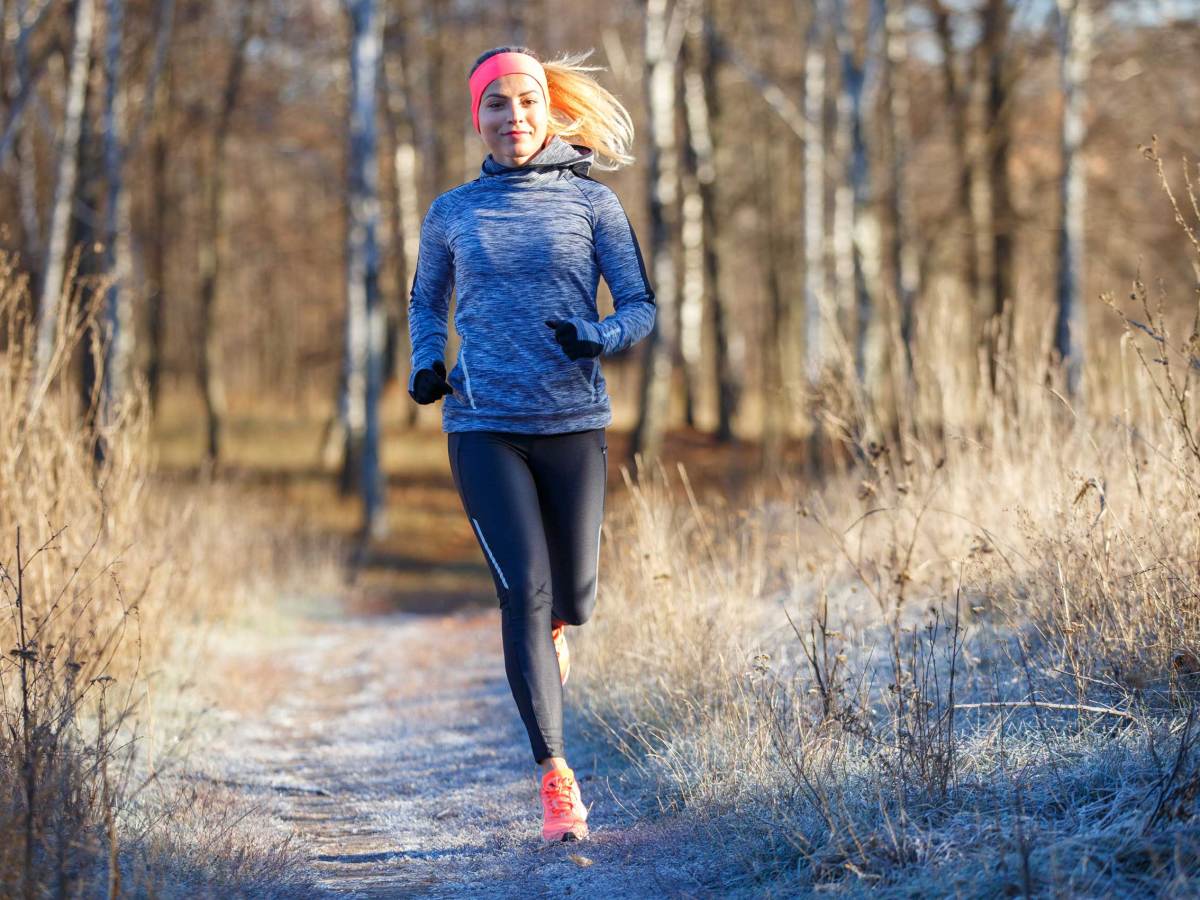 Junge, athletische Frau läuft im Park im Spätherbst oder frühen Winter