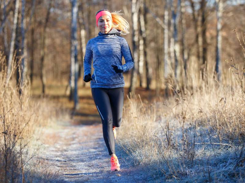 Junge, athletische Frau läuft im Park im Spätherbst oder frühen Winter