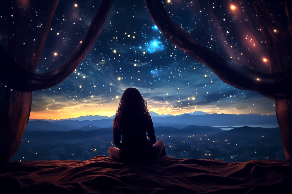 Eine Frau sitzt im Schneidersitz vor dem Sternenhimmel