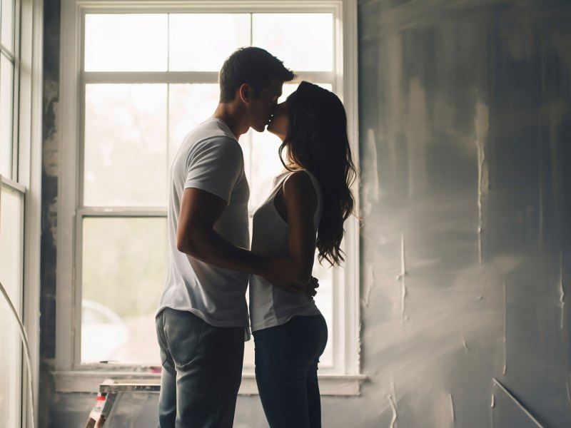 Paar küsst sich in einer leeren Wohnung