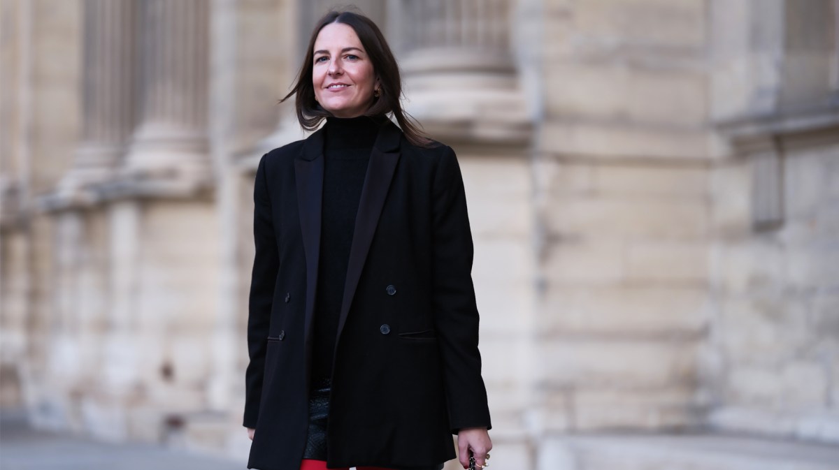 Influencerin, die ein schwarzes Outfit mit einer roten Strumpfhose kombiniert.