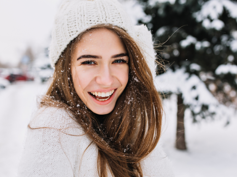 Frau im Schnee, die glücklich zur Seite schaut
