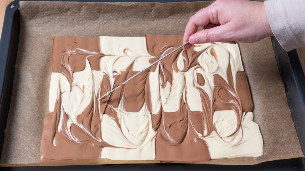 Geschmolzene Schokoladentafeln auf Backblech.