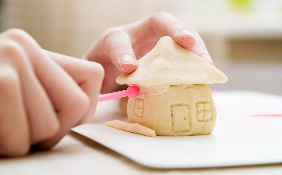 Salzteig-Rezept: Kinderhand formt Häuschen aus Salzteig