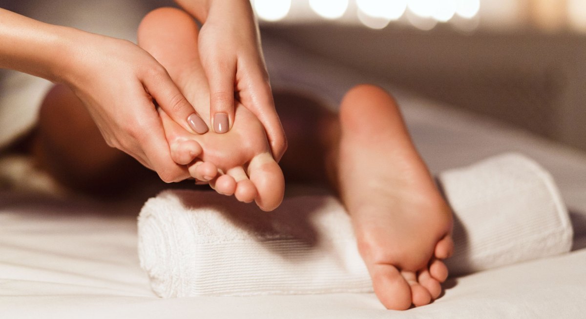 Fußmassage: Manikürte Finger massieren Füße