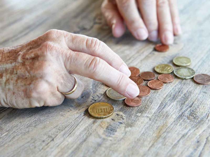 Ältere Frau zählt Kleingeld.