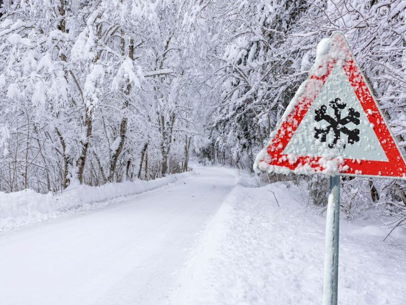 Eine schneebedeckte Landschaft mit einem Straßenschild