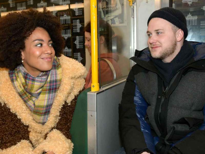 GZSZ-Figuren Flo Kästner, gespielt von Pauline Afaja und Jonas Seefeld, gespielt von Felix van Deventer sitzen in der Berliner U-Bahn.