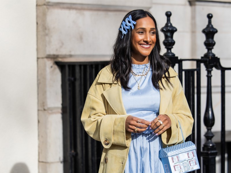 Streetstyle der London Fashion Week im Frühling 2024 mit einem Trenchcoat und hellblauen Kleid