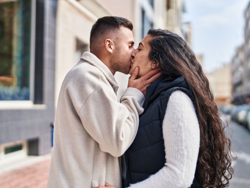 Junges heterosexuelles Paar küsst sich auf der Straße