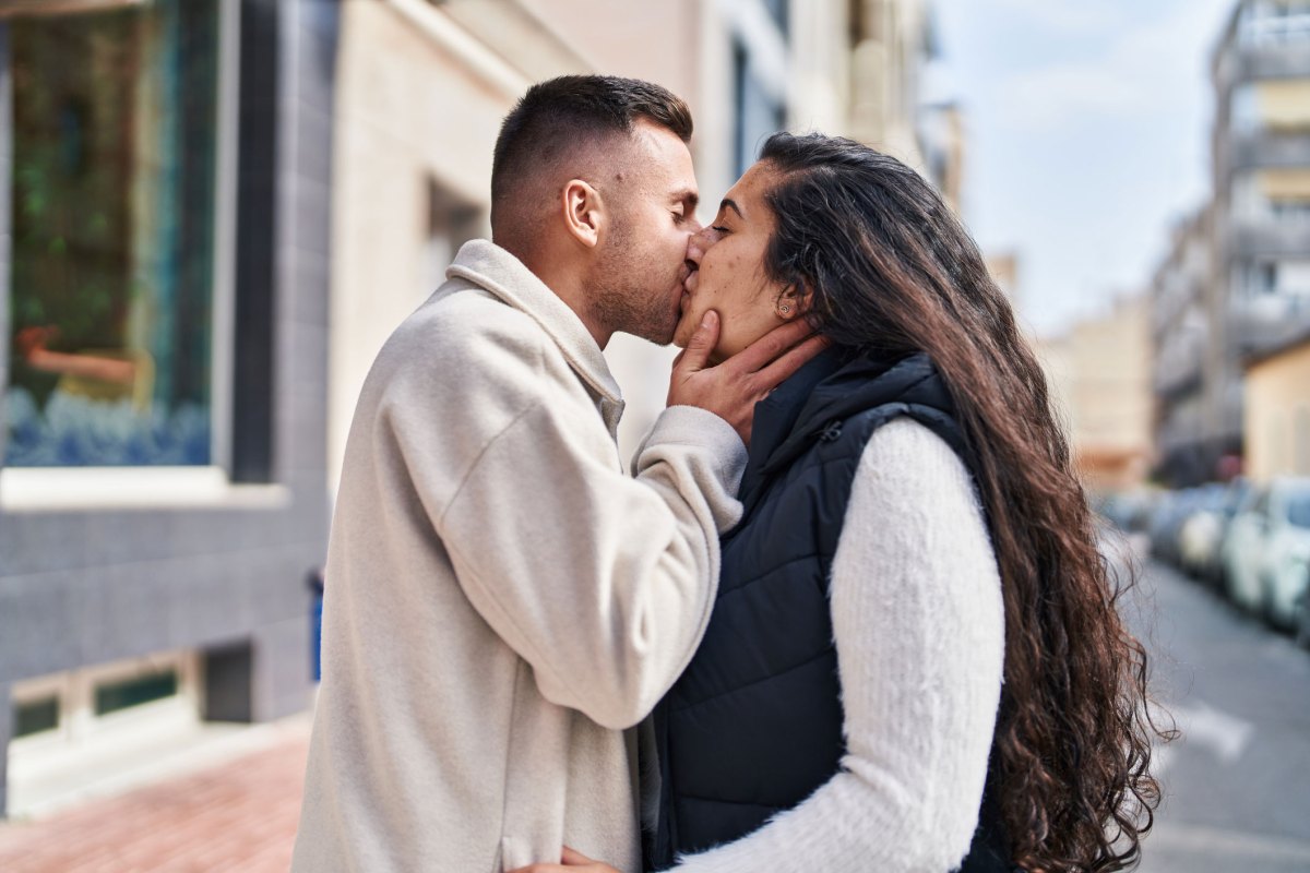 Junges heterosexuelles Paar küsst sich auf der Straße