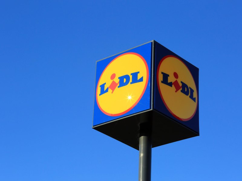 Großes Lidl-Logo am blauen, wolkenlosen Himmel