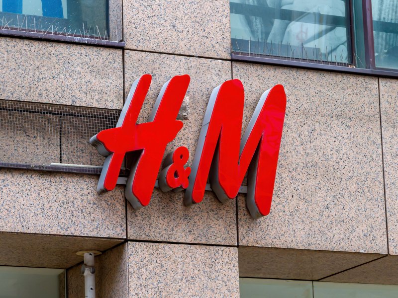 H&M Logo mit großen, roten Lettern über einem Eingang eines H&M-Stores.