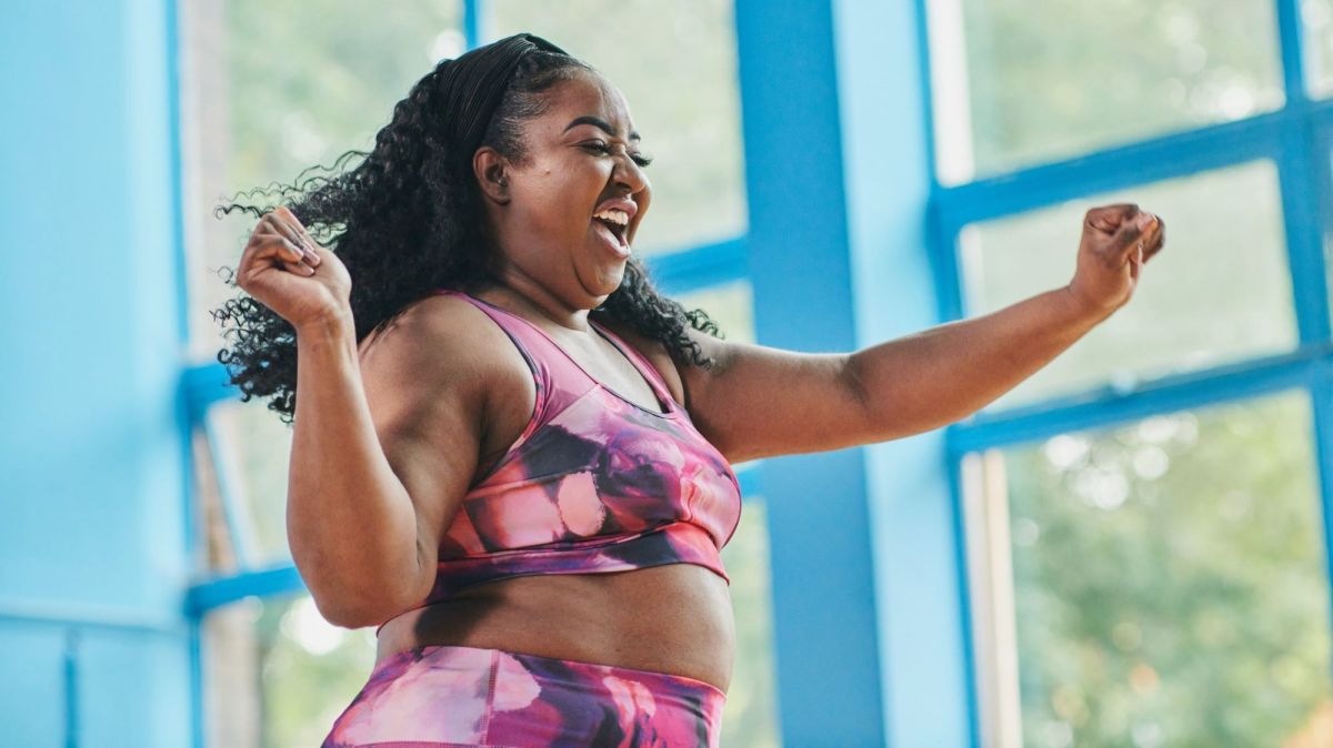 Frau lacht glücklich während sie Dance Fitness macht.