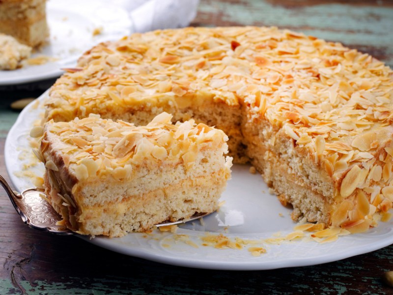 Mandeltorte mit Eierlikörcreme in der Mitte auf weißem Teller.