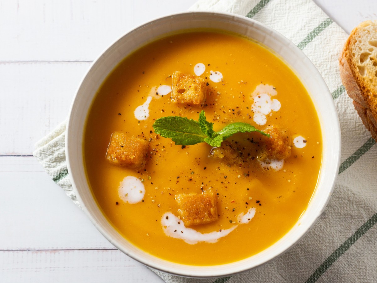 Möhrensuppe mit Croûtons in weißer Schüssel.