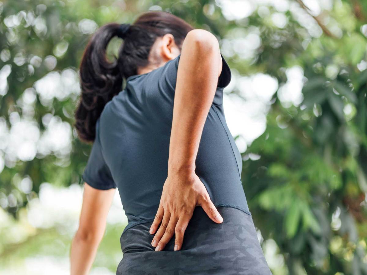 Frau im Garten mit Rückenschmerzen