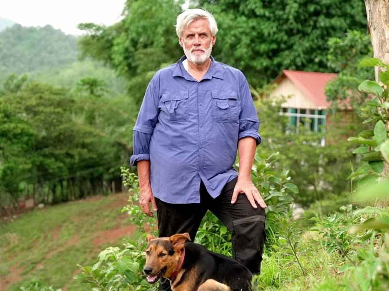 Andreas (63) aus Guatemala mit seinem Hund auf seinem Hof.