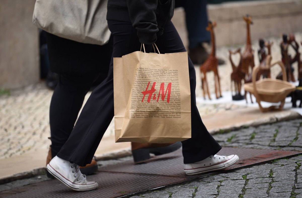 Frau, die eine Einkaufstüte von H&M trägt.