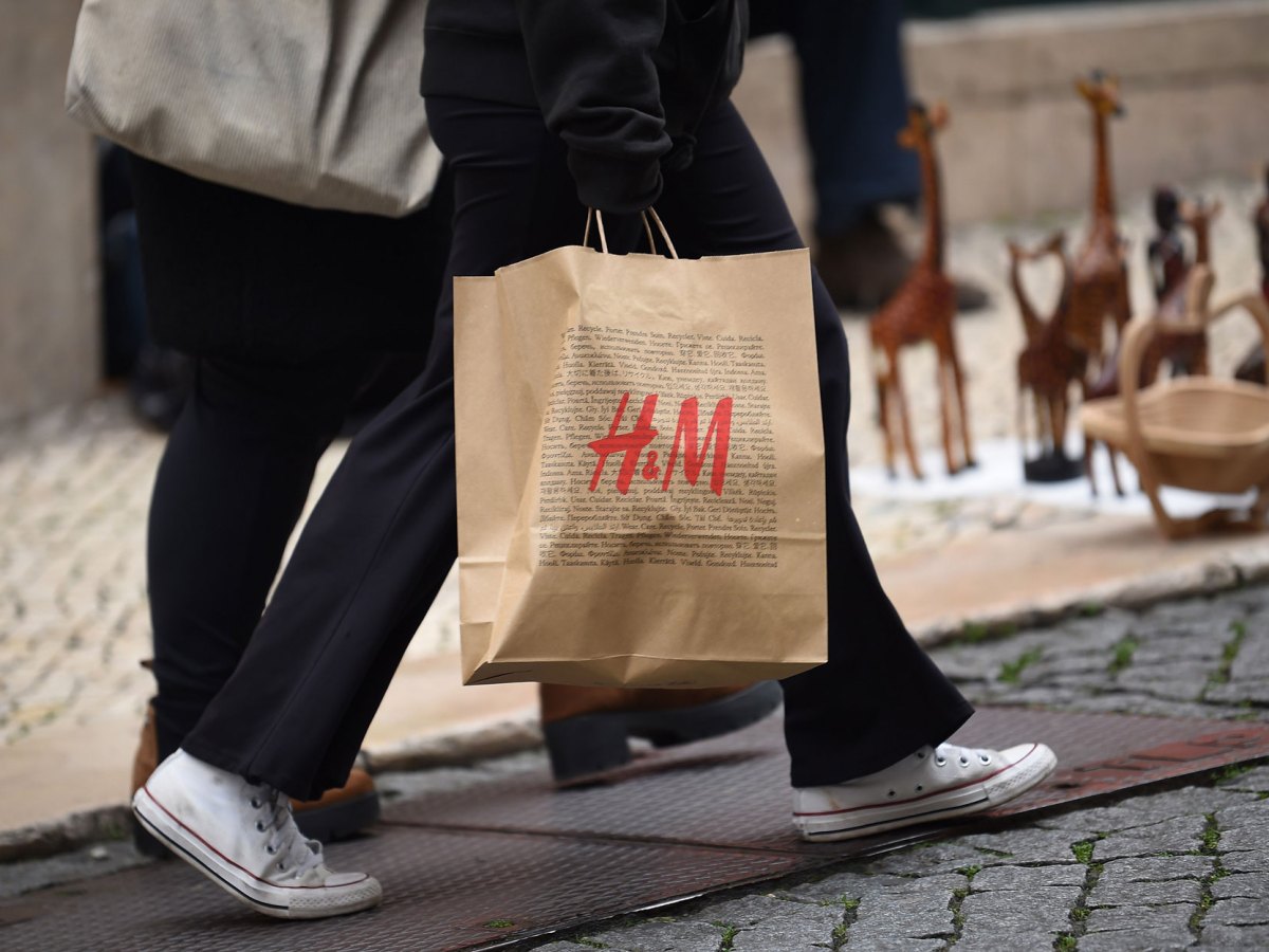Frau, die eine Einkaufstüte von H&M trägt.